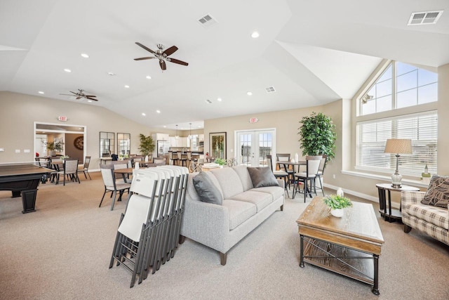 living room featuring light carpet, visible vents, a ceiling fan, and lofted ceiling