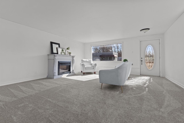 living room with a glass covered fireplace, baseboards, and carpet floors