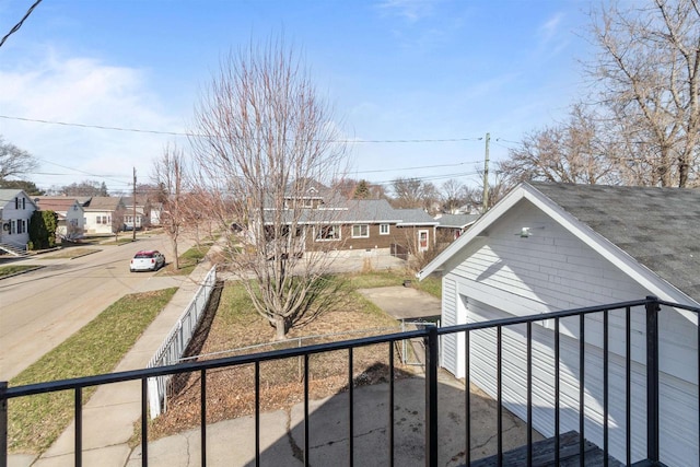 view of yard featuring a residential view, a garage, and a fenced front yard