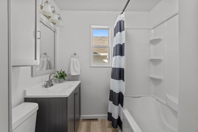 bathroom featuring vanity, shower / tub combo with curtain, toilet, visible vents, and wood finished floors