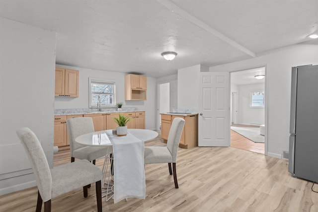 dining area with light wood-type flooring and baseboards