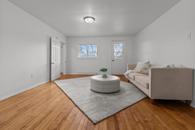 living room featuring wood-type flooring, baseboards, and a baseboard heating unit