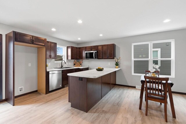 1143 Fillmore Ave, Oshkosh, WI 54902 - kitchen featuring stainless steel appliances, light countertops, a sink, dark brown cabinetry, and a peninsula