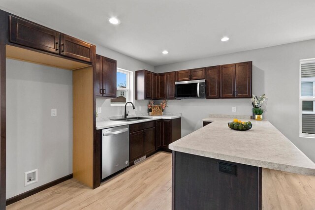 1143 Fillmore Ave, Oshkosh, WI 54902 - kitchen with light wood finished floors, stainless steel appliances, a sink, dark brown cabinetry, and recessed lighting