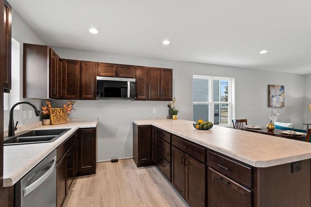 1143 Fillmore Ave, Oshkosh, WI 54902 - kitchen featuring dark brown cabinetry, a peninsula, appliances with stainless steel finishes, and a sink