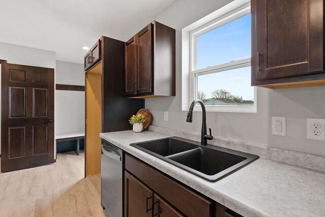 1143 Fillmore Ave, Oshkosh, WI 54902 - kitchen with dark brown cabinetry, dishwasher, light countertops, and a sink