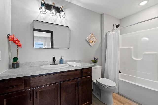 1143 Fillmore Ave, Oshkosh, WI 54902 - full bath featuring shower / tub combo with curtain, wood finished floors, toilet, and vanity