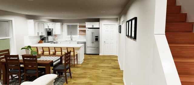 1143 Fillmore Ave, Oshkosh, WI 54902 - kitchen with a sink, stainless steel microwave, white cabinetry, fridge with ice dispenser, and light countertops