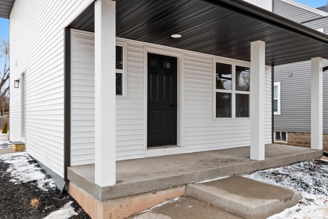 1143 Fillmore Ave, Oshkosh, WI 54902 - snow covered property entrance featuring covered porch