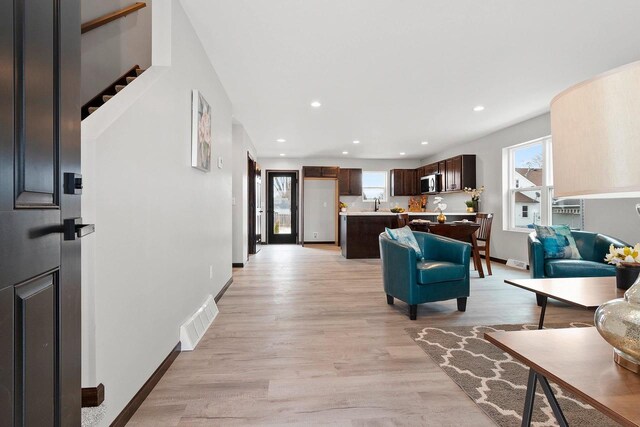 1143 Fillmore Ave, Oshkosh, WI 54902 - living room with light wood-type flooring, baseboards, visible vents, recessed lighting, and stairs