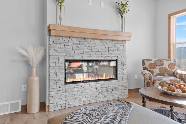 3106 Lazy Oak Dr, Green Bay, WI 54311 - living room with visible vents, a stone fireplace, baseboards, and wood finished floors