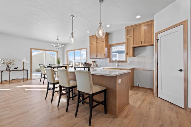 3106 Lazy Oak Dr, Green Bay, WI 54311 - kitchen featuring an inviting chandelier, light wood-type flooring, recessed lighting, a center island, and decorative backsplash