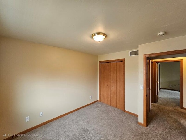 unfurnished bedroom featuring visible vents, baseboards, carpet flooring, and a closet