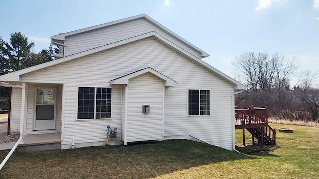 rear view of house featuring a deck and a lawn