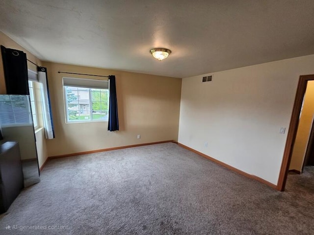 carpeted empty room with visible vents and baseboards