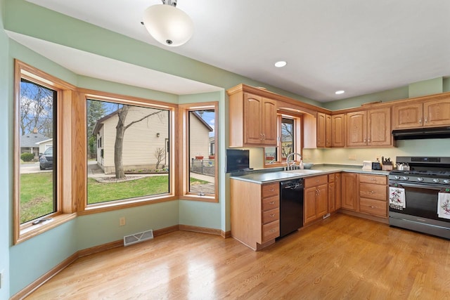 kitchen with stainless steel range with gas cooktop, black dishwasher, under cabinet range hood, visible vents, and a sink