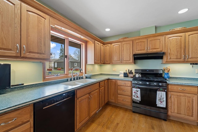 kitchen featuring black dishwasher, a sink, stainless steel gas range, under cabinet range hood, and light wood-style flooring