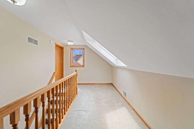 bonus room featuring light colored carpet, visible vents, and lofted ceiling with skylight