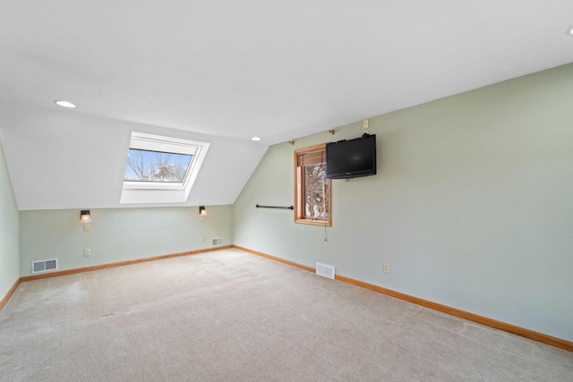 bonus room featuring carpet, visible vents, baseboards, and lofted ceiling with skylight