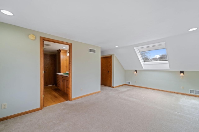 additional living space featuring visible vents, baseboards, and light colored carpet