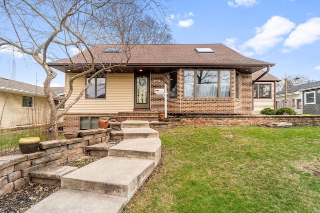 bungalow featuring a front yard, brick siding, and a shingled roof