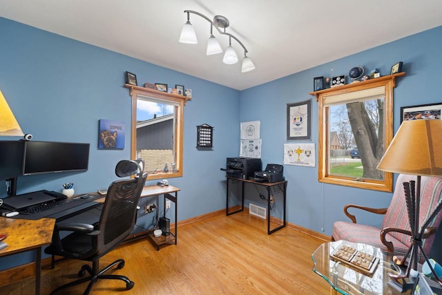 office featuring wood finished floors, baseboards, and visible vents