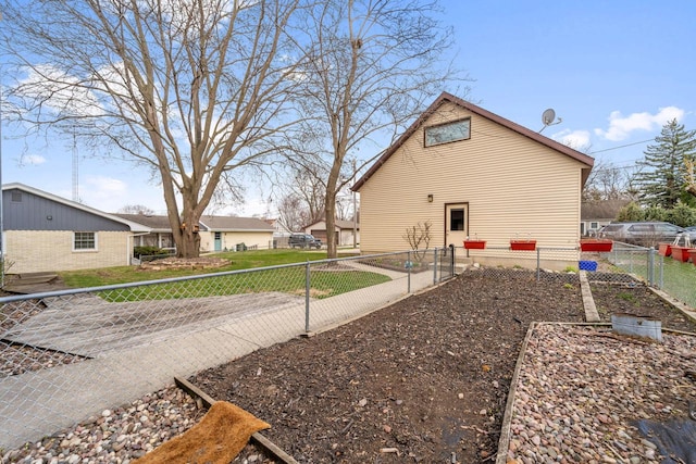 view of home's exterior with a garden and fence private yard
