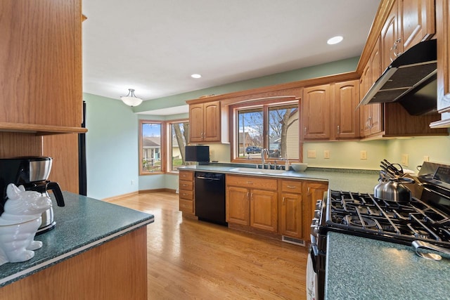 kitchen with dishwasher, a sink, light wood-style floors, under cabinet range hood, and gas range oven
