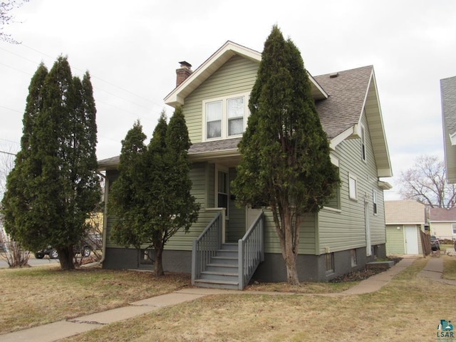 1125 N 22nd St, Superior, WI 54880 - view of front of property with roof with shingles, a chimney, and a front lawn