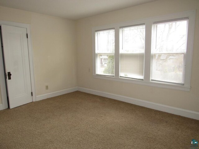 1125 N 22nd St, Superior, WI 54880 - carpeted spare room featuring baseboards and plenty of natural light