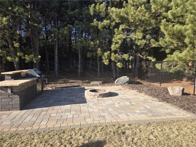E8577 N County Rd, Elk Mound, WI 54739 - view of patio featuring exterior kitchen, a fire pit, a grill, and fence