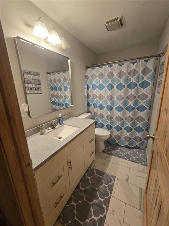 E8577 N County Rd, Elk Mound, WI 54739 - bathroom with vanity, a shower with curtain, visible vents, toilet, and marble finish floor