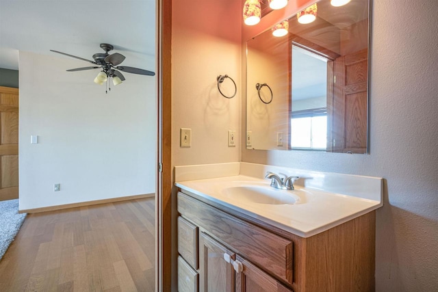 bathroom with wood finished floors, vanity, and a ceiling fan