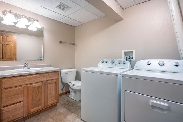 laundry room featuring visible vents, baseboards, a sink, laundry area, and washing machine and dryer
