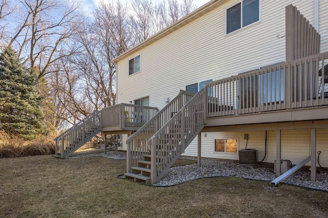 back of house featuring a lawn, a wooden deck, central AC unit, and stairs