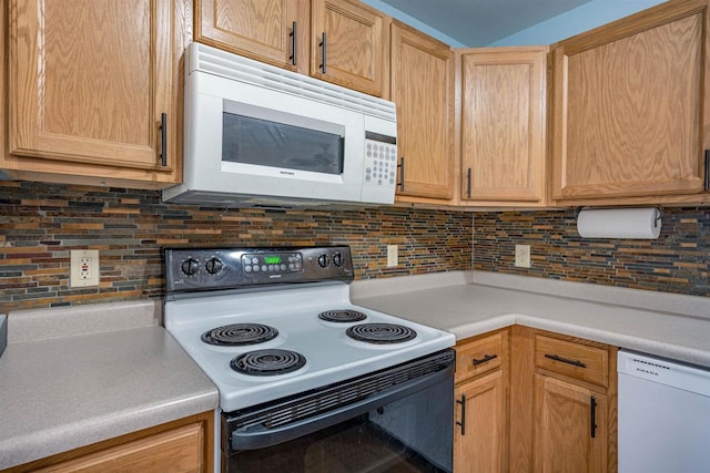 kitchen featuring light brown cabinetry, decorative backsplash, light countertops, and white appliances