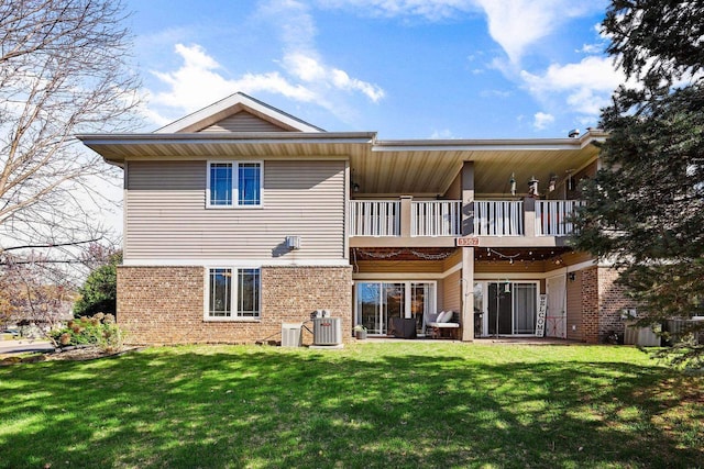 rear view of house featuring brick siding, a lawn, a balcony, and cooling unit