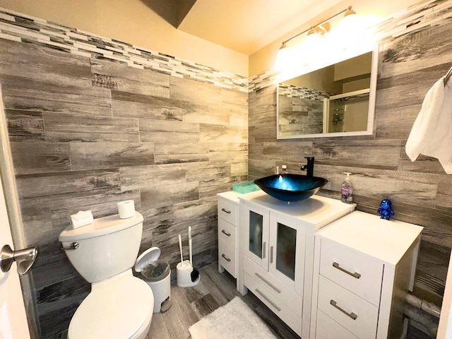 full bath featuring wooden walls, toilet, and a shower with door