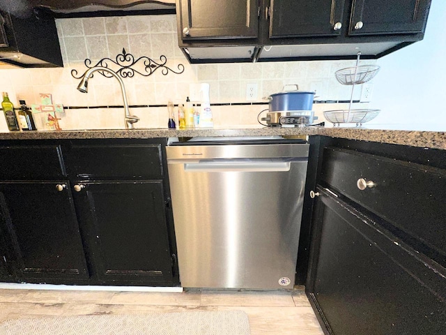 kitchen featuring dark cabinets, light wood-style floors, dishwasher, and decorative backsplash