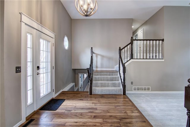 entryway with visible vents, a chandelier, wood finished floors, and stairs