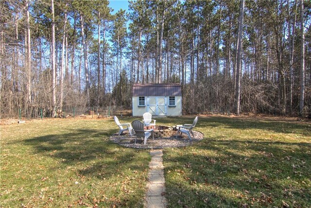 view of yard with a storage shed, an outdoor fire pit, and an outdoor structure