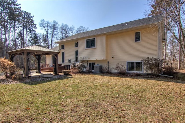 back of property featuring central AC unit, a gazebo, and a lawn