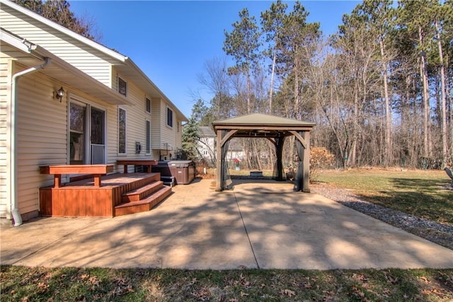 view of patio / terrace with a gazebo, a wooden deck, and a hot tub