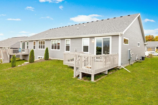 back of property featuring roof with shingles, a yard, and a deck