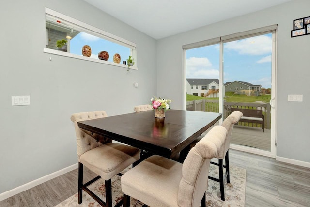 dining room featuring light wood-style floors, baseboards, and plenty of natural light