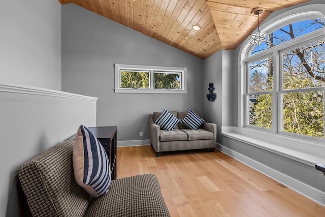sitting room featuring a wealth of natural light, vaulted ceiling, and baseboards