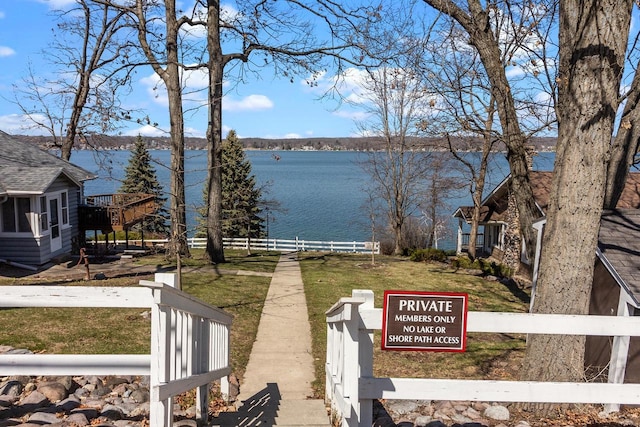 view of yard with a water view and fence