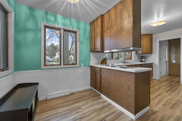 kitchen featuring brown cabinets, light wood-style floors, visible vents, a peninsula, and electric stovetop