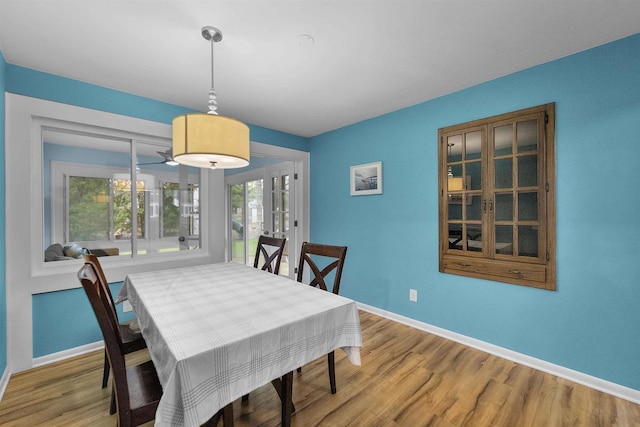 dining space featuring baseboards and light wood finished floors