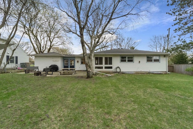 rear view of property with fence, a lawn, entry steps, and a patio